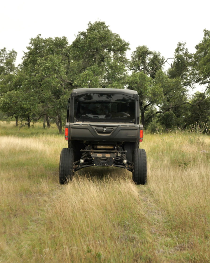 Off-road vehicle driving through golden prairie grassland
